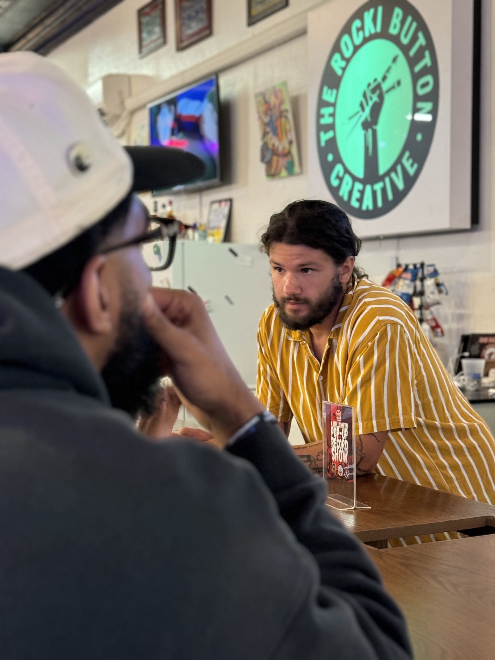 Bartender serving a drink to a patron at The Rocki Button Art Gallery in South Bend